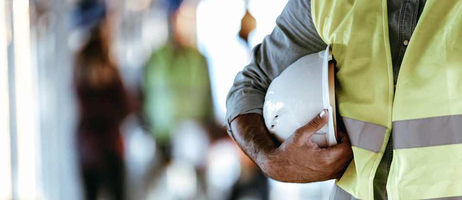 Architect worker holding white helmet a for workers security control at city site